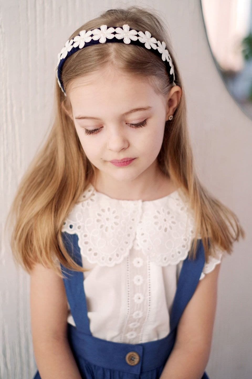 Niña con diadema de flores blancas